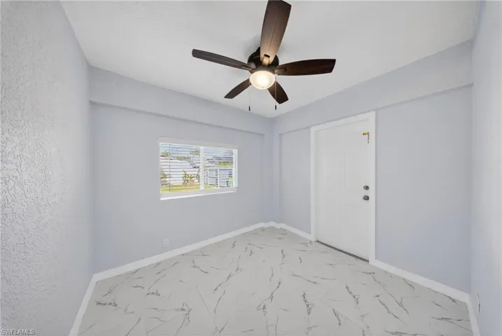Room featuring marble-look tile flooring, a horizontal window with blinds, and a ceiling fan with integrated lighting