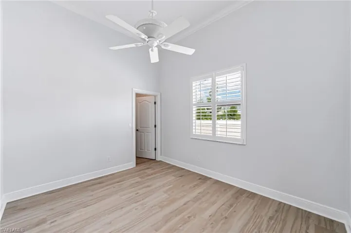 Empty room featuring ceiling fan, light hardwood / wood-style flooring, and crown molding