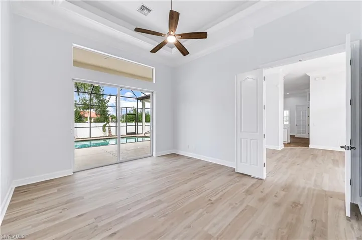Unfurnished room with ceiling fan, light hardwood / wood-style flooring, and ornamental molding