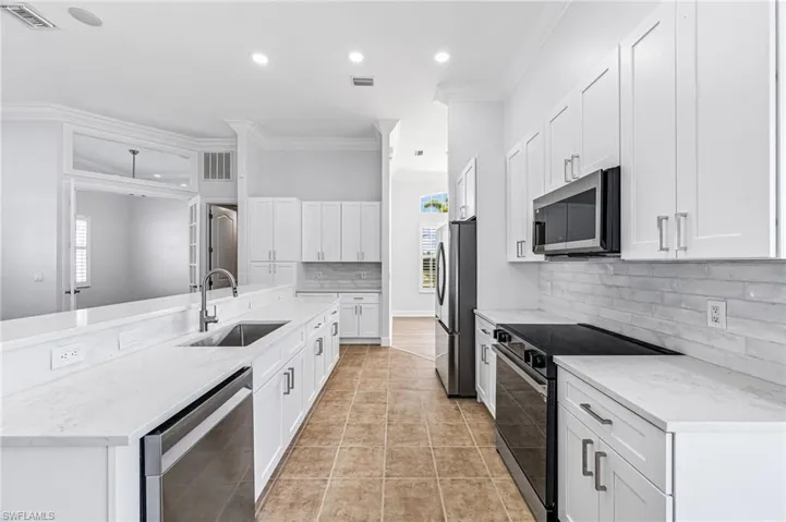Kitchen with white cabinets, appliances with stainless steel finishes, plenty of natural light, and sink