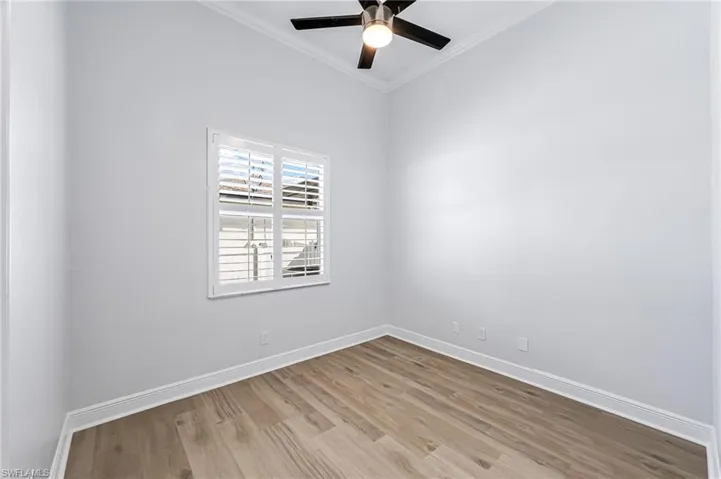 Unfurnished room with crown molding, light hardwood / wood-style floors, and ceiling fan