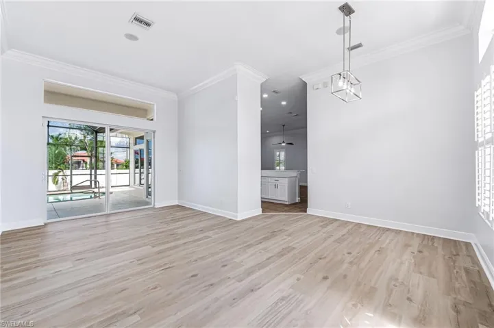 Unfurnished living room featuring light wood-type flooring and crown molding