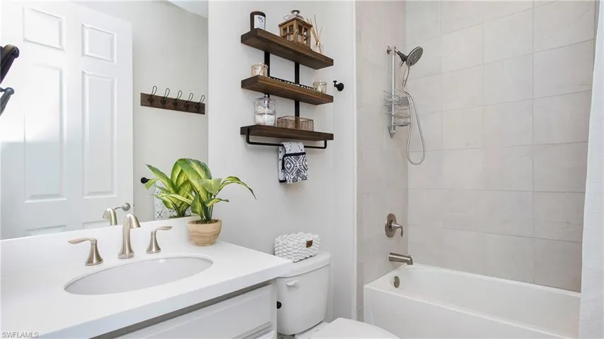 Full Guest bathroom featuring tiled shower / bath combo, and vanity