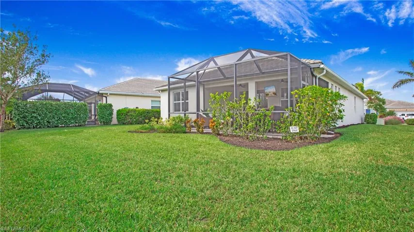 Rear view of house with a yard and screen enclosure