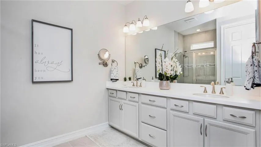 Bathroom with vanity, tile patterned floors, and walk in shower