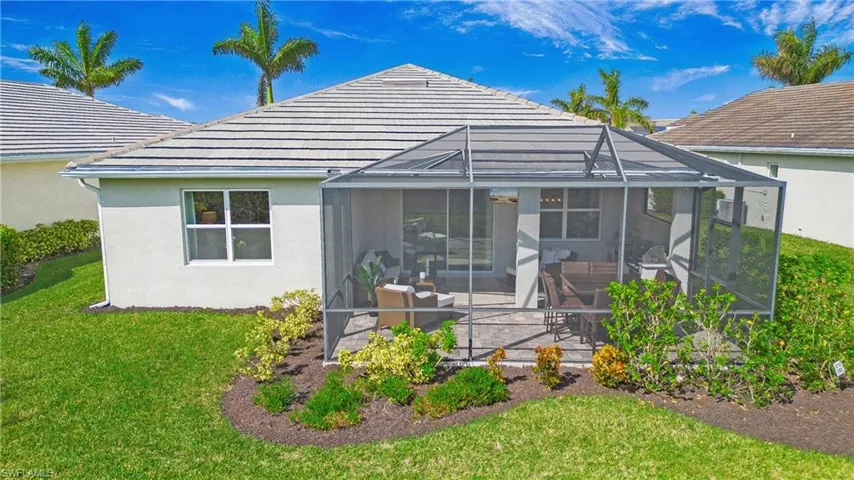Back of house featuring a yard, a patio, and glass enclosure