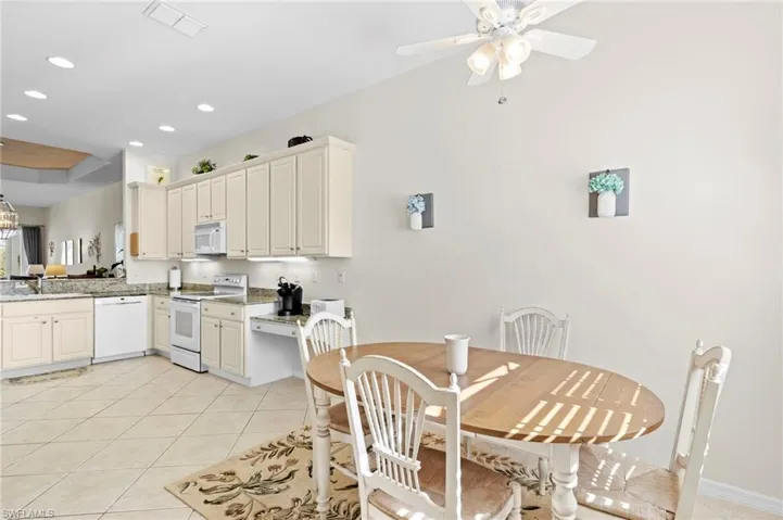 Tiled dining space featuring sink and ceiling fan
