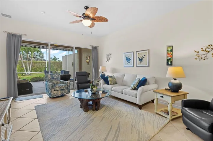 Living room with ceiling fan and light tile floors
