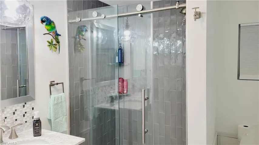 Bathroom featuring vanity, tiled shower and and toilet