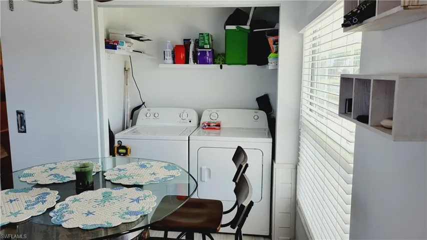 Clothes washing area featuring laundry area and washer and clothes dryer hidden behind barn doors.