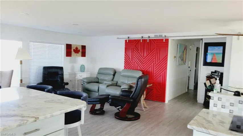 Living area with light vinyl finished floors and a barn door