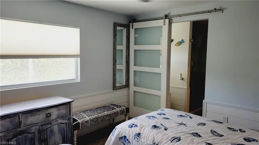 2nd Bedroom with a barn door leading into 2nd bath and wainscoting