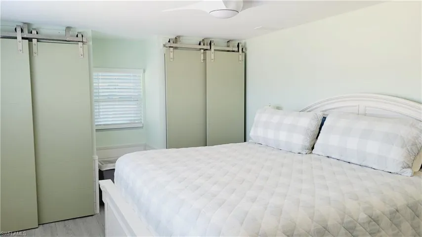 Master Bedroom with a barn door and light wood-style vinyl floors. Double closets.