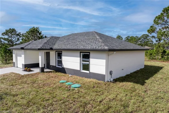 View of side of home with a yard and a garage