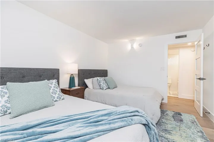 Guest Bedroom featuring white walls and light wood-finish flooring