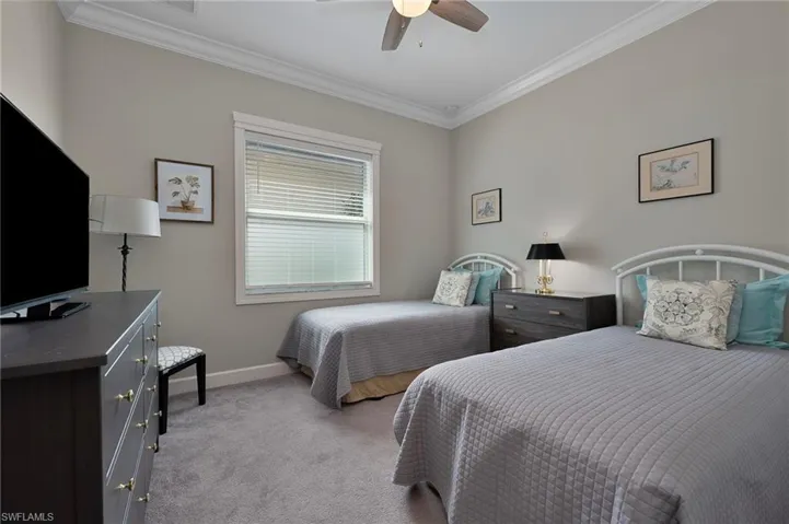 Bedroom featuring  moldings, light colored carpet, and ceiling fan