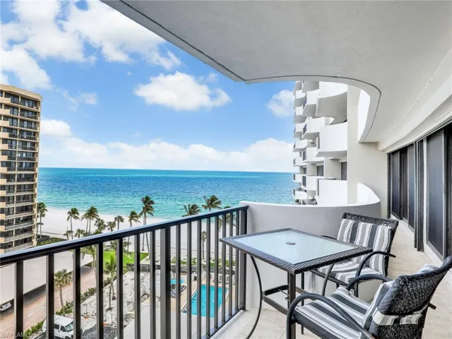 Balcony with a water view and view of pool area