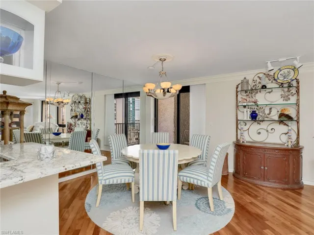 Dining area with a chandelier, light wood-style flooring, and ornamental molding