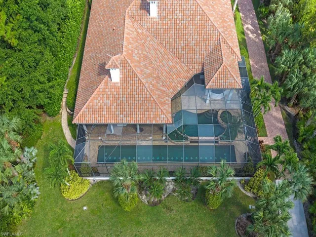 Expansive property featuring a Mediterranean-style residence with a terracotta roof, surrounded by mature trees and lush landscaping