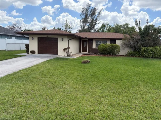 Ranch-style home featuring driveway, an attached garage, and stucco siding