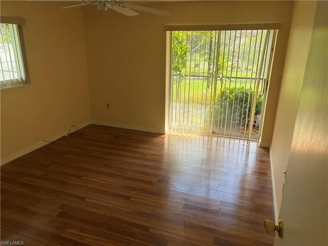 Spare room featuring dark wood-type flooring and a ceiling fan