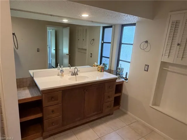 Bathroom featuring vanity, light tile patterned floors, and a textured ceiling