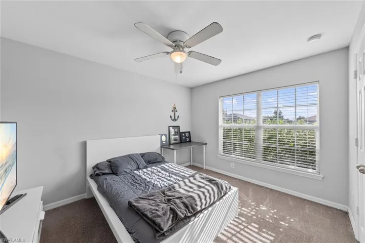 Carpeted bedroom with ceiling fan