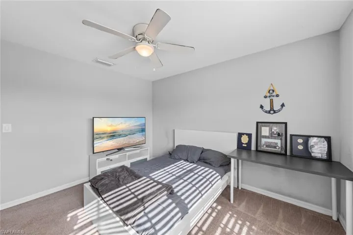 Bedroom featuring ceiling fan and carpet