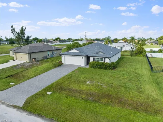 View of front of property featuring a front lawn and a garage