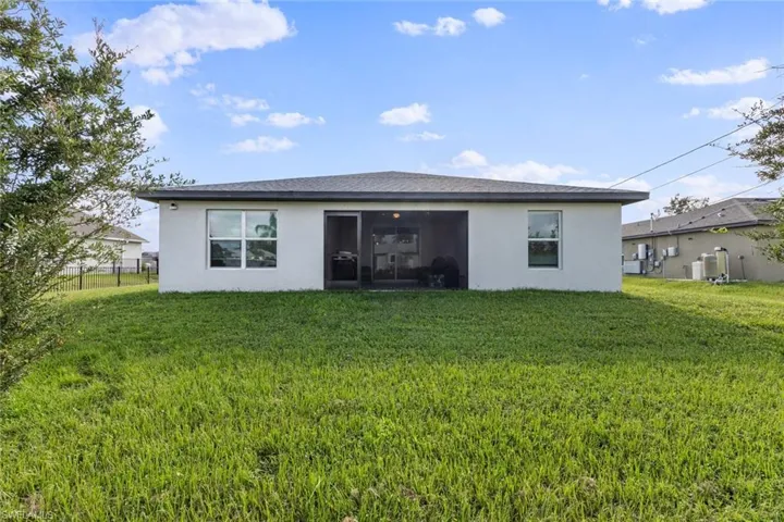 Back of property with a lawn