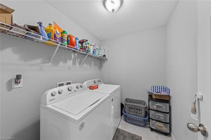 Laundry room featuring washing machine and dryer and light tile patterned floors
