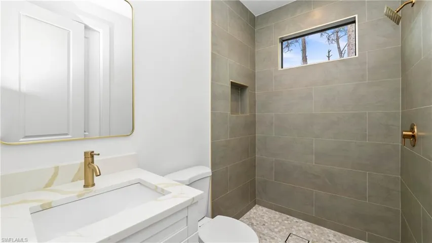 Full bath with vanity and tiled shower