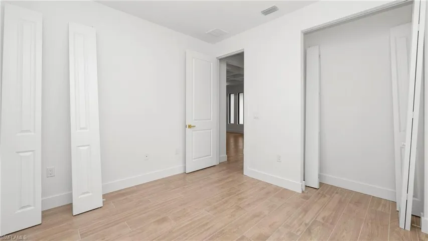 Unfurnished bedroom with wood tiled floors and baseboards