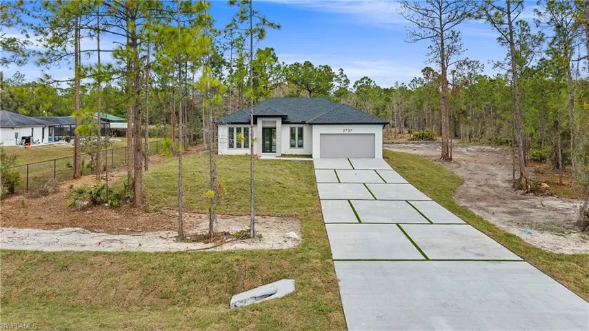 View of front of home featuring a garage and concrete driveway