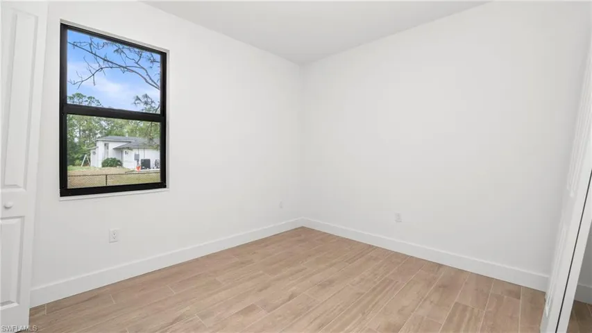 Unfurnished room with light wood finished floors and baseboards
