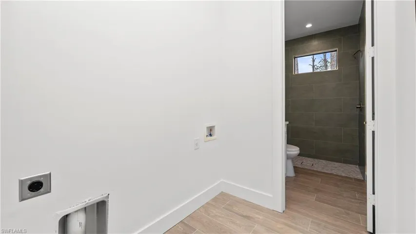 Washroom with washer hookup, electric dryer hookup, and wood finish floors