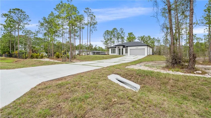 View of front of house with concrete driveway and a garage