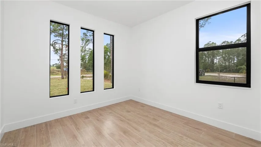 Spare room with baseboards and light wood-type flooring