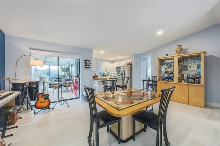 Dining space featuring light wood-style floors, lofted ceiling, and recessed lighting