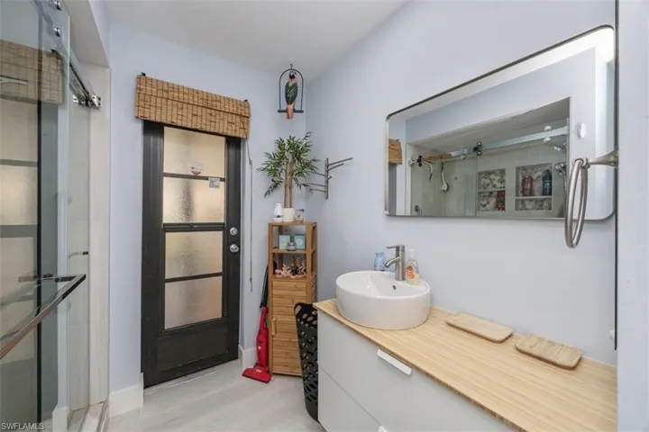 Bathroom featuring a shower stall, vanity, and light wood-style floors