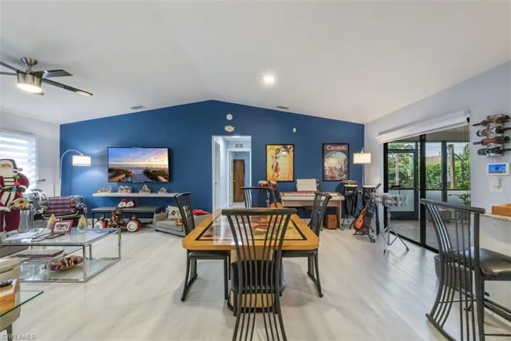 Dining area with plenty of natural light, lofted ceiling, light wood-style floors, and a ceiling fan