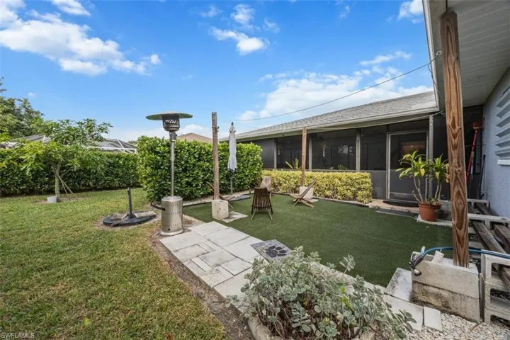 View of green lawn featuring a sunroom and a patio