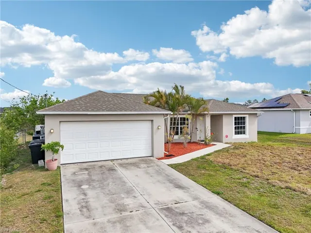Ranch-style home featuring roof with shingles, concrete driveway, stucco siding, an attached garage, and a front lawn