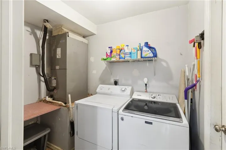 Clothes washing area featuring laundry area and washer and clothes dryer