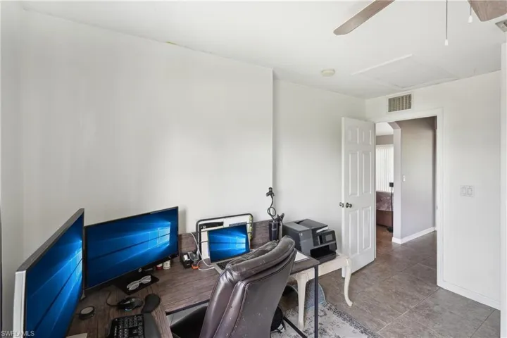 Home office featuring attic access, baseboards, visible vents, and ceiling fan