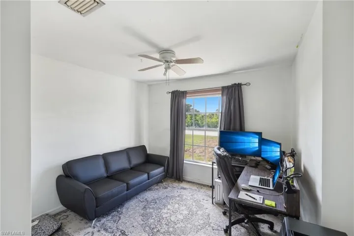 Home office with baseboards, visible vents, and a ceiling fan