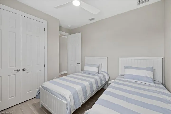 Bedroom with hardwood / wood-style floors, a closet, and ceiling fan