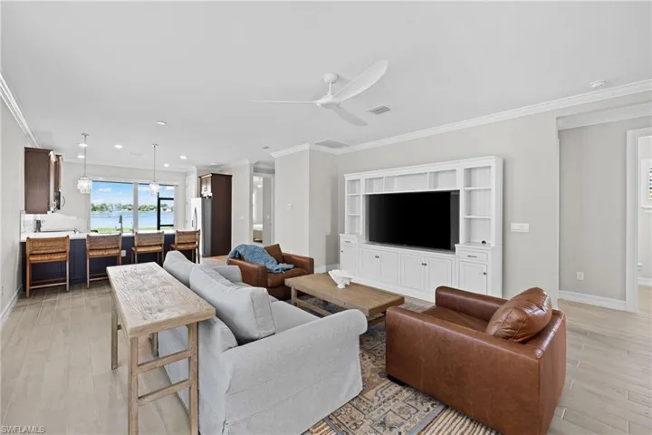 Living room featuring light hardwood / wood-style floors, ornamental molding, and ceiling fan