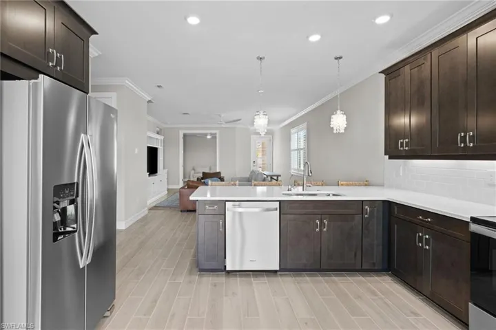 Kitchen featuring tasteful backsplash, appliances with stainless steel finishes, sink, and kitchen peninsula