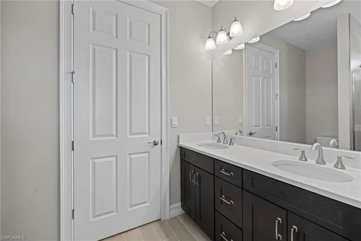 Bathroom featuring hardwood / wood-style floors, double vanity, and toilet
